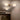 Moderne plafondlamp met drie witte glazen bollen en gouden armatuur in minimalistisch interieur.
