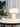 Witte marmeren tafellamp met gouden details op moderne tafel, naast boeken en decoratief beeldje.
