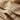 Beige satijnen overhemd met knoopsluiting, close-up van stof en knoopsgat.