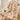Beige pluche deken op stoel met groene appel en krant, luxe interieurdecoratie.