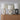 Drie moderne tafellampen met ovale basis, wit en zwart, op houten dressoir.