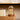 Glazen stolp met houten basis, oranje tulpen, decoratieve verlichting, moderne woondecoratie.