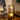 Gouden tafellamp met glazen cilinder, sfeerverlichting, modern design, houten tafel.