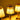 Drie gouden tafellampen met stoffen lampenkappen, warm licht, elegante woondecoratie.