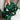 Man in groene satijnen pyjama zittend op bed, luxe nachtkleding, comfortabele slaapkleding.