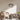 Moderne glazen hanglamp in woonkamer, rotan stoel, houten kast, boeken, Scandinavisch interieur.