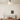 Witte plafondlamp in moderne slaapkamer, houten bed, beige muurdecoratie.
