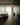 Moderne woonkamer met glazen wand, minimalistisch interieur, beige tinten, designmeubels.