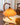 Moderne oranje tafellamp met gebogen houten voet op marmeren tafel, sfeerverlichting woonkamer.