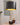 Zwarte tafellamp met gouden details op houten tafel, moderne interieurdecoratie.