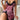Vrouw in roze luipaardprint nachtjapon met zwarte kanten details, zittend op een witte bank.