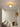 Gouden plafondlamp met moderne uitstraling in minimalistische witte ruimte.