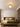 Gouden plafondlamp in moderne slaapkamer, strakke inrichting, sfeerverlichting, designlamp.