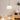 Moderne glazen hanglamp boven houten eettafel, Scandinavisch interieur, warme verlichting.