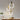 Moderne hanglamp met drie LED-ringen, goudkleurig, boven houten eettafel, minimalistisch design.
