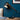 Moderne minimalistische tafellamp, zwart metaal en bruin leer, op houten tafel tegen blauwe muur.