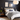 Moderne slaapkamer met grijs dekbedovertrek, houten bed, zwarte muur, wandlampen, en kunstwerken.