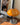 Oranje Quadrifoglio tafellamp op houten tafel, moderne designlamp, chromen voet, interieurdecoratie.