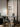 Moderne glazen hanglamp boven zwarte tafel in minimalistisch interieur met laptop en stoel.