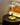 Moderne messing tafellamp met glazen kap op houten tafel, naast New York poster.
