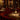 Luxe restaurantinterieur met gedimde verlichting, ronde tafels, rode banken en elegante tafellampen.
