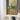 Groene tafellamp met gouden voet op witte kast, moderne interieurdecoratie.