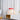 Rode tafellamp op witte kast, moderne designlamp, messing details, interieurdecoratie.