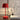 Rode tafellamp, modern design, naast abstract kunstwerk en boek op houten tafel.