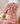 Roze pluchen deken op stoel met open boek en groene appel, gezellige interieurdecoratie.