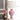 Roze keramische tafellamp met witte kap, decoratieve vaas, bloemen, moderne woondecoratie.