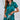 Vrouw in groene satijnen pyjama met korte mouwen en hartdetail, comfortabele nachtkleding.