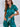Vrouw in groene satijnen pyjama met korte mouwen en hartdetail, comfortabele nachtkleding.
