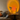 Sfeervolle woonkamer met oranje LED-lamp, moderne bank, kussens en decoratieve glazen op tafel.