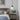 Moderne slaapkamer met hanglamp, leren bed, nachtkastje, bloemenvaas en kunst aan de muur.