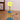 Gele spiraalvormige tafellamp met smiley gezicht, blauwe basis, moderne decoratieve verlichting.