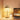 Moderne houten tafellamp met warme LED-verlichting naast laptop en vetplant op bureau.