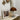 Bruine glazen tafellamp op witte plank naast ingelijste foto en decoratieve bezem.