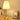 Gouden tafellamp met geplooide kap op houten bureau, sfeerverlichting, moderne inrichting.
