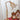 Antieke messing tafellamp met glazen kap op rode tafel, vintage decor, klassieke stijl.