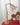 Antieke messing tafellamp met glazen kap op rode tafel, vintage decor, klassieke stijl.