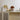 Bruine glazen tafellamp op beige kast met decoratieve vazen en gele bloemen.