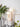 Moderne keramische tafellamp, beige, met twee ronde lampen, op witte kast naast planten.