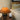 Bruine tafellamp op houten tafel naast beige bank en abstract schilderij.