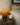Bruine tafellamp op houten tafel naast beige bank en abstract schilderij.