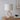Witte tafellamp met abstracte keramische voet op houten tafel, moderne interieurdecoratie.