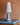 Blauwe keramische tafellamp met witte kap op houten tafel, moderne interieurdecoratie.