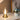 Glazen tafellamp met gouden voet, moderne decoratie, warm licht, naast bloemenvaas.