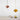 Twee hanglampen, koper en geel, modern design, boven minimalistisch bureau met boeken en fruit.