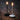 Twee moderne LED-kaarslampen, zwart en wit, op houten vloer, sfeerverlichting.