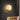 Moderne wandlamp met houten tak en ronde glazen bol, sfeerverlichting woonkamer.